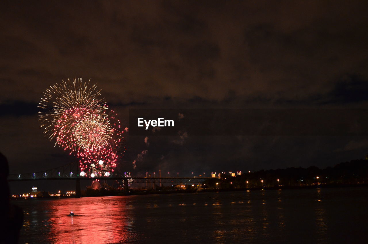 Firework display over river at night