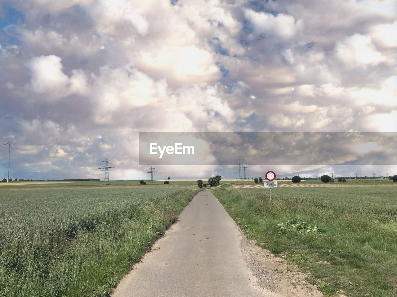 EMPTY ROAD ALONG FIELD