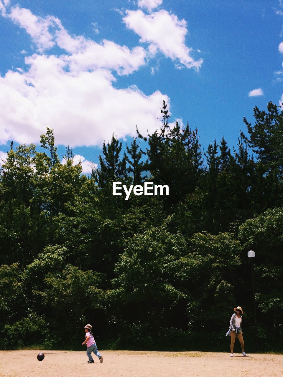 Mother and son on playground against sky