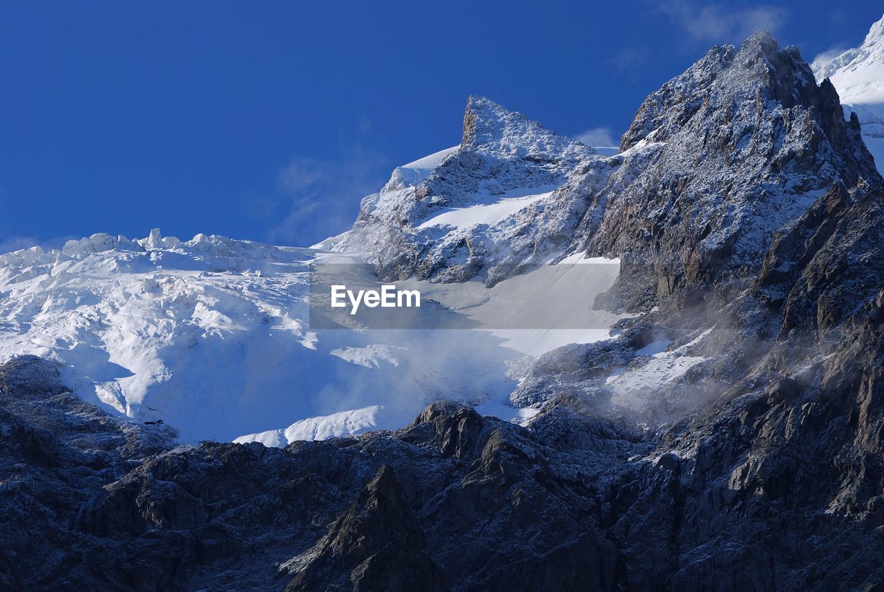 Snow covered mountain against blue sky