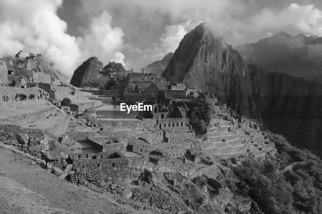 Panoramic view of mach picchu ruins against cloudy sky