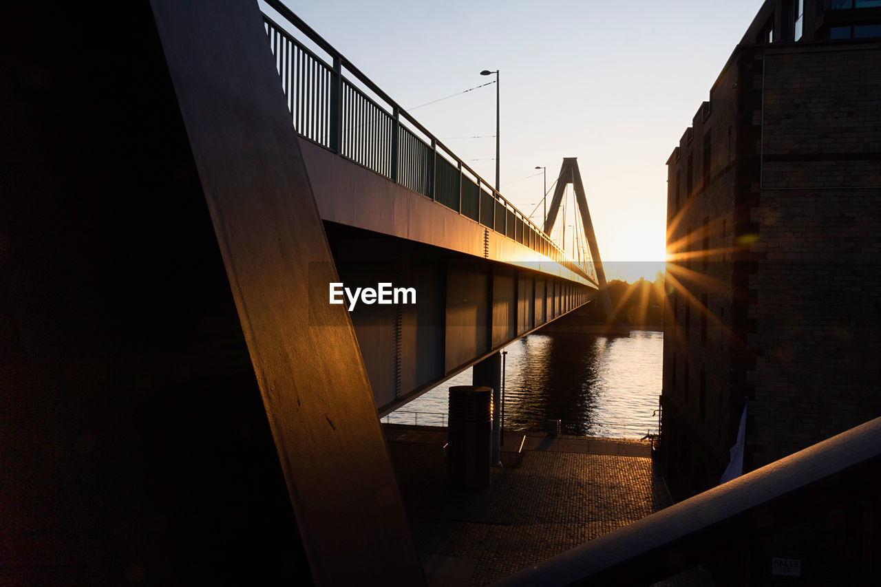Bridge over footbridge against sky during sunset