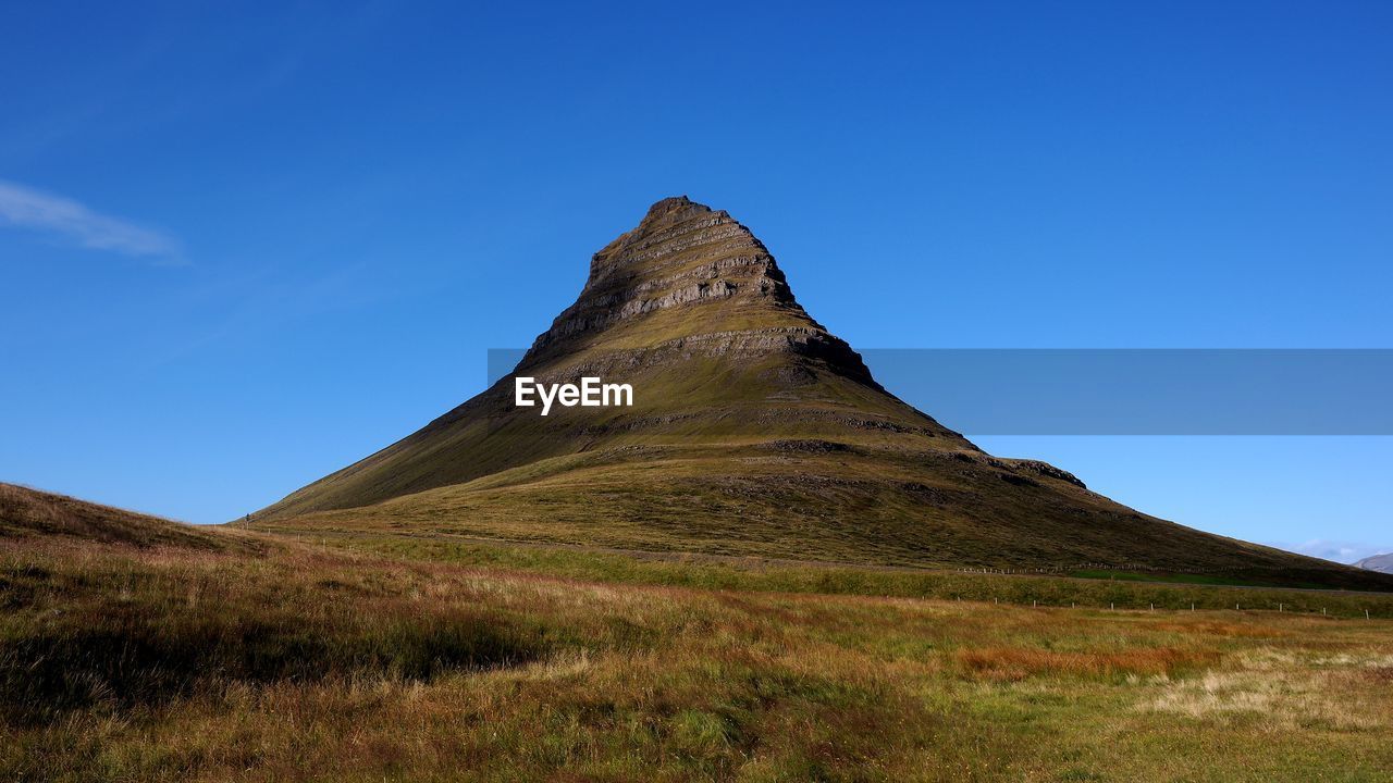 Low angle view of mountain against blue sky