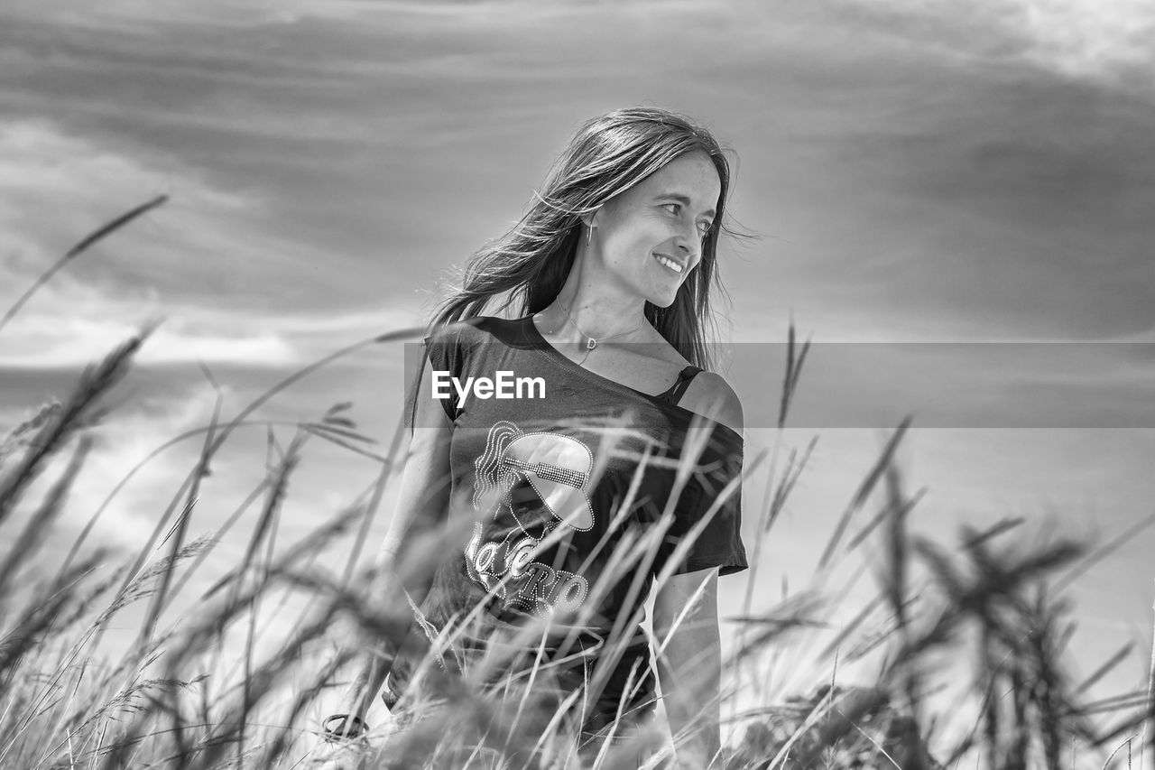 Woman standing on field against sky