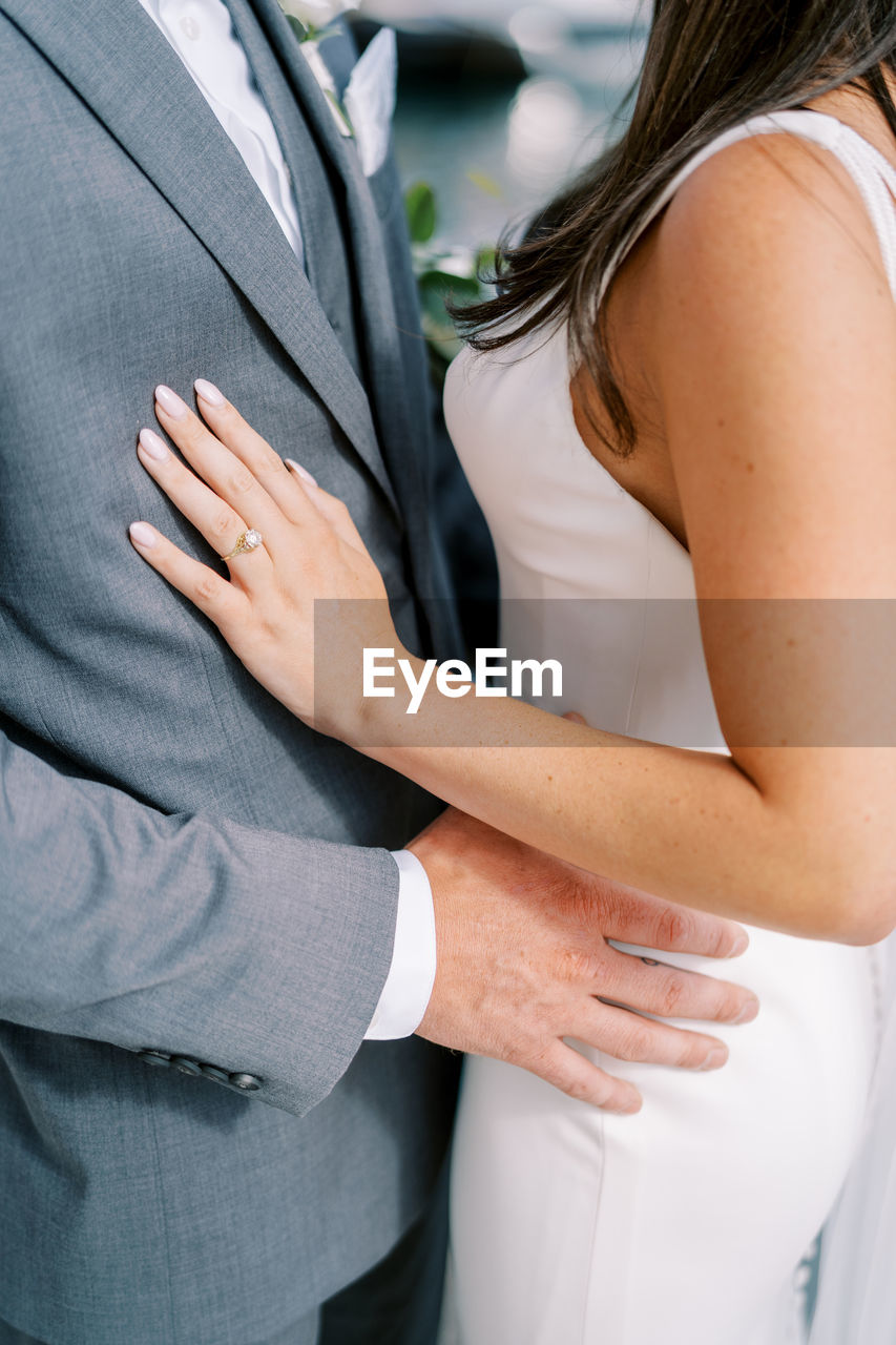 midsection of bride and groom