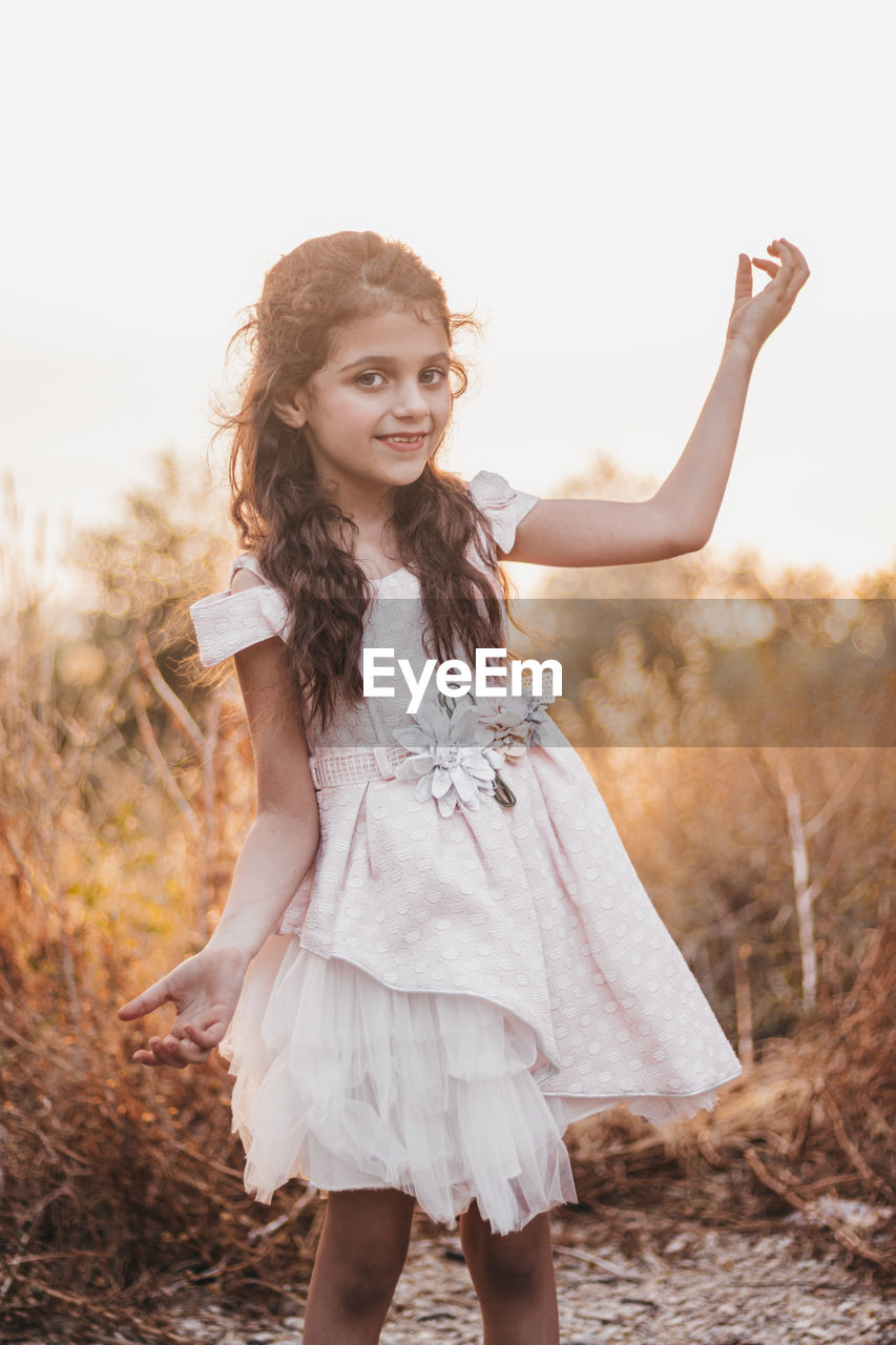 Little girl dancing in nature during a sunset