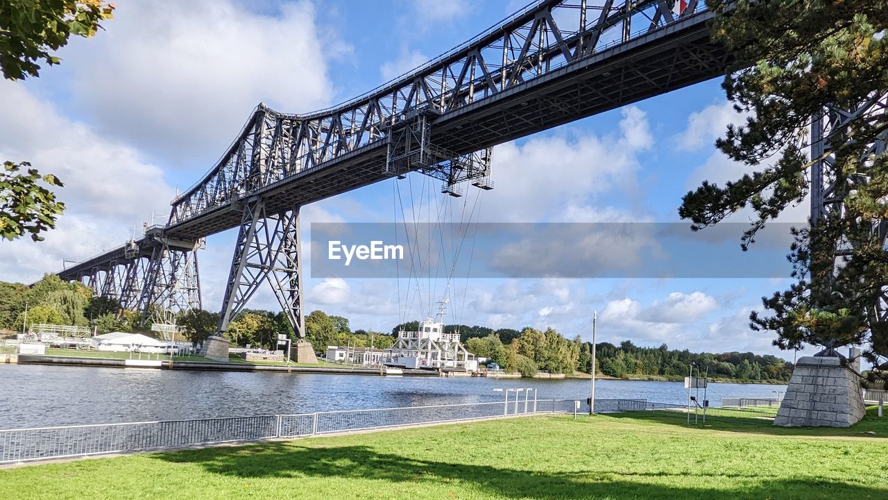 architecture, water, built structure, sky, bridge, nature, plant, cloud, transportation, travel destinations, tree, travel, day, city, no people, tourism, river, grass, outdoors, sunlight, park, beauty in nature, landscape, building exterior, environment, landmark, summer, business finance and industry, scenics - nature, land
