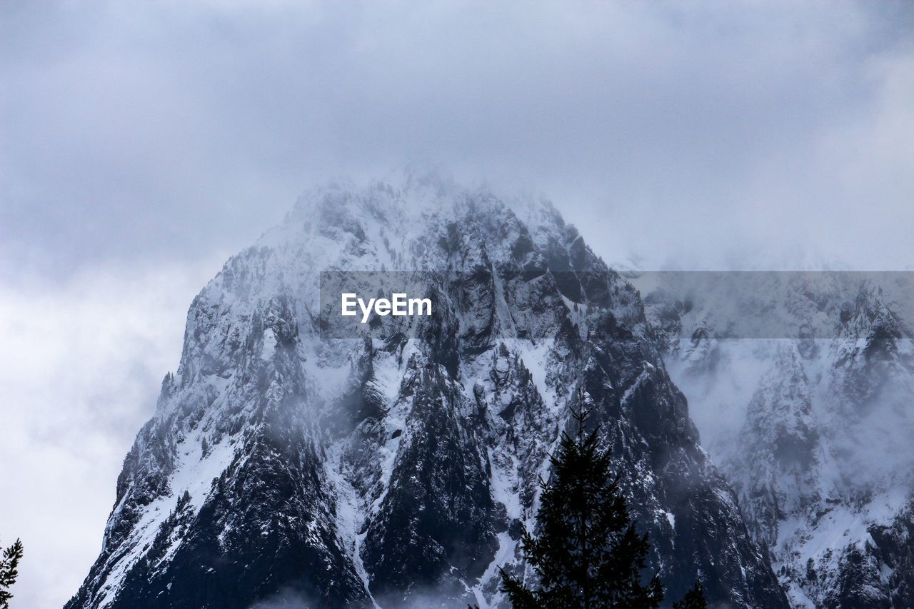 Low angle view of snowcapped mountains against sky