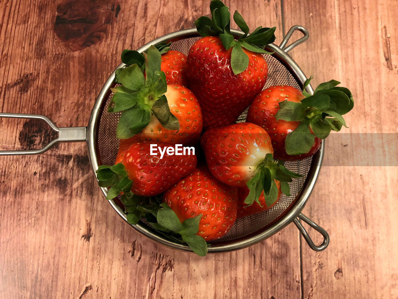 High angle view of strawberries in sieve on table