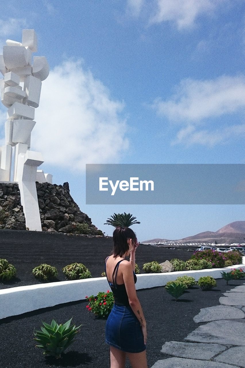 Woman standing in city against sky