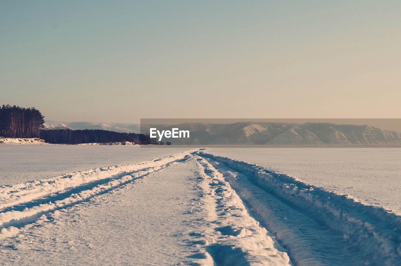 Scenic view of snow covered mountains against clear sky