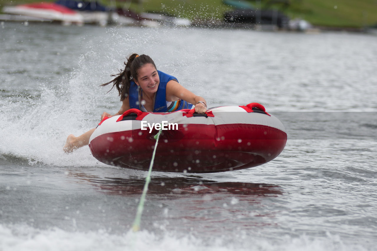 Teenage girl tubing in lake