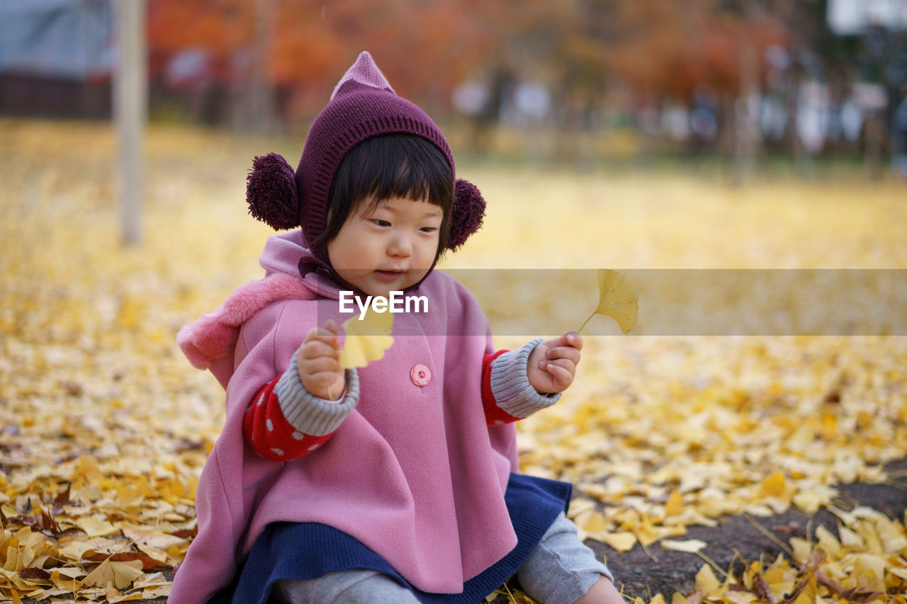 Close-up of cute girl in autumn leaves