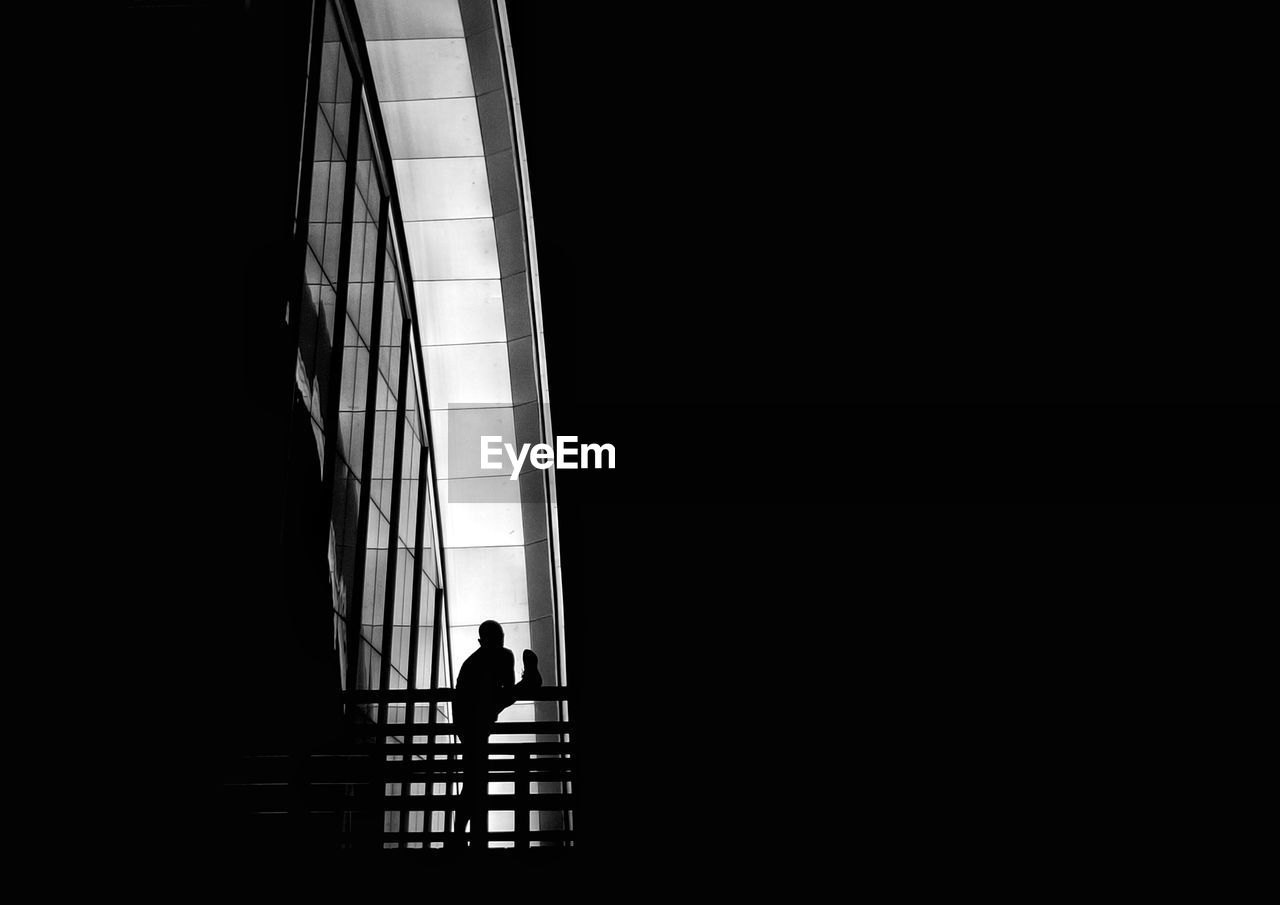 Silhouette man standing by building