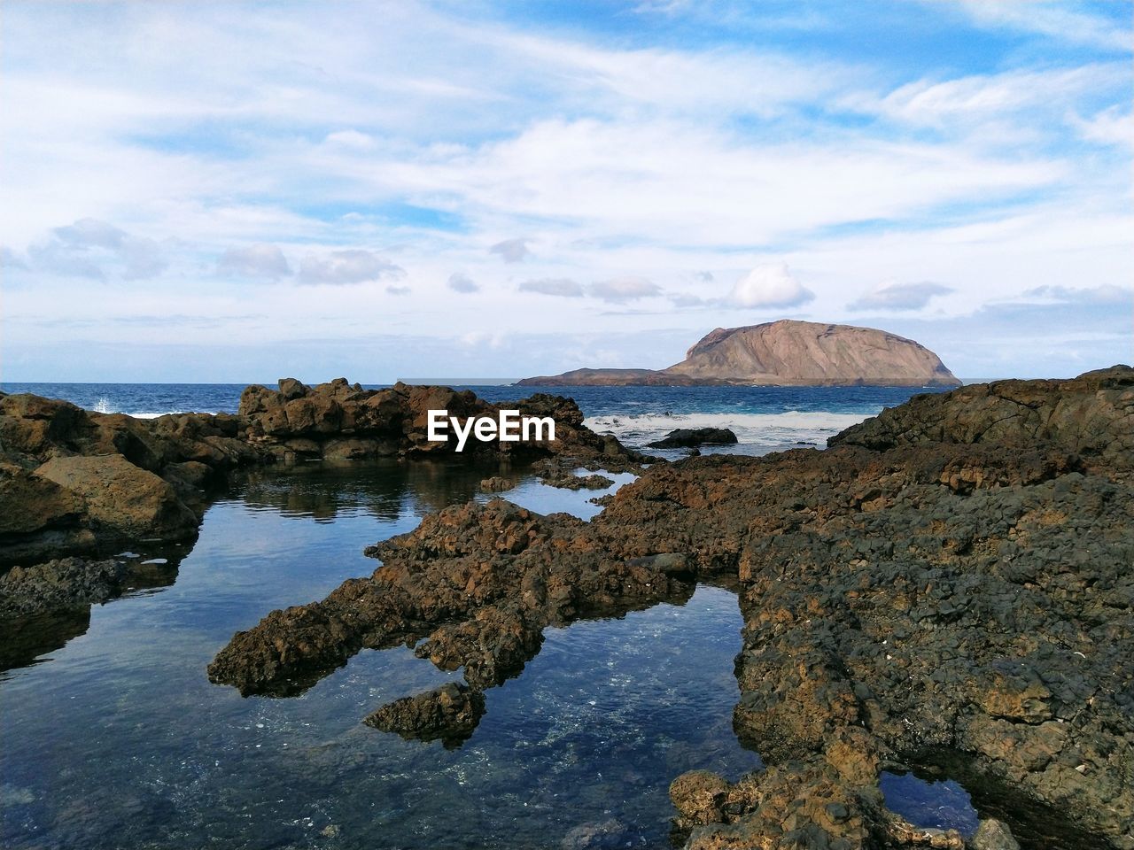 Rocks on sea shore against sky
