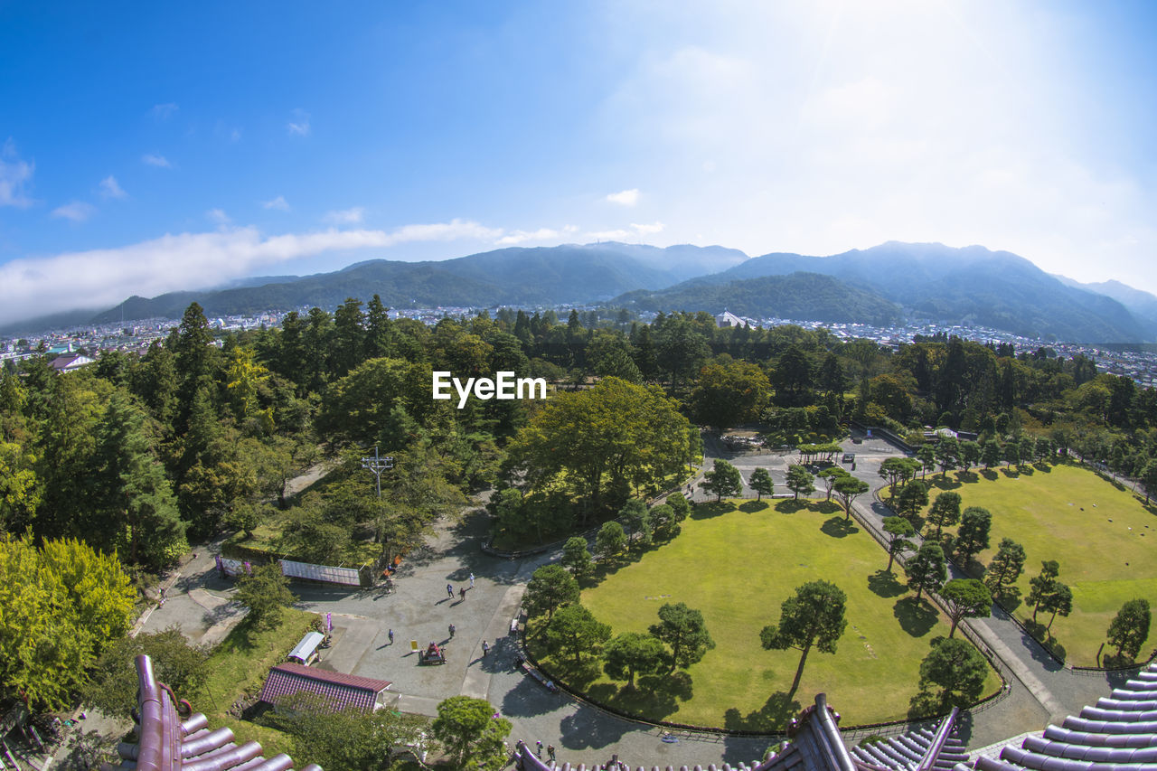 HIGH ANGLE VIEW OF BUILDINGS AND TREES AGAINST SKY