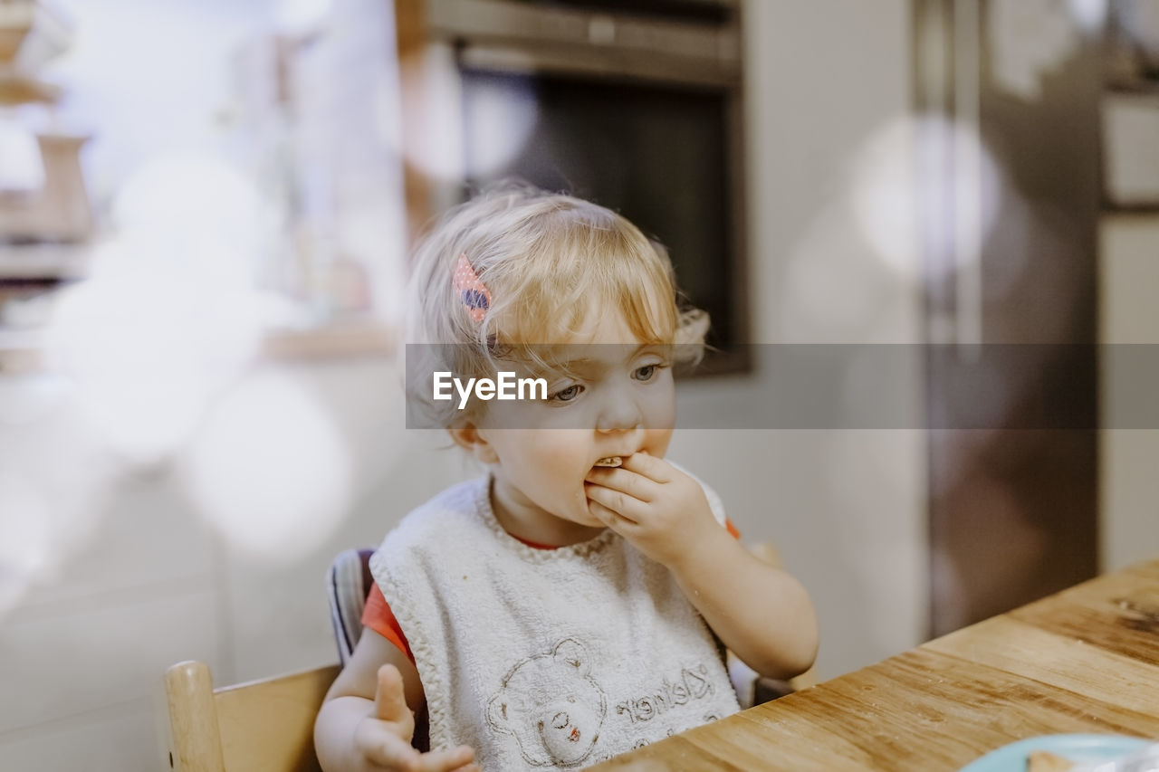 Cute girl eating food at home