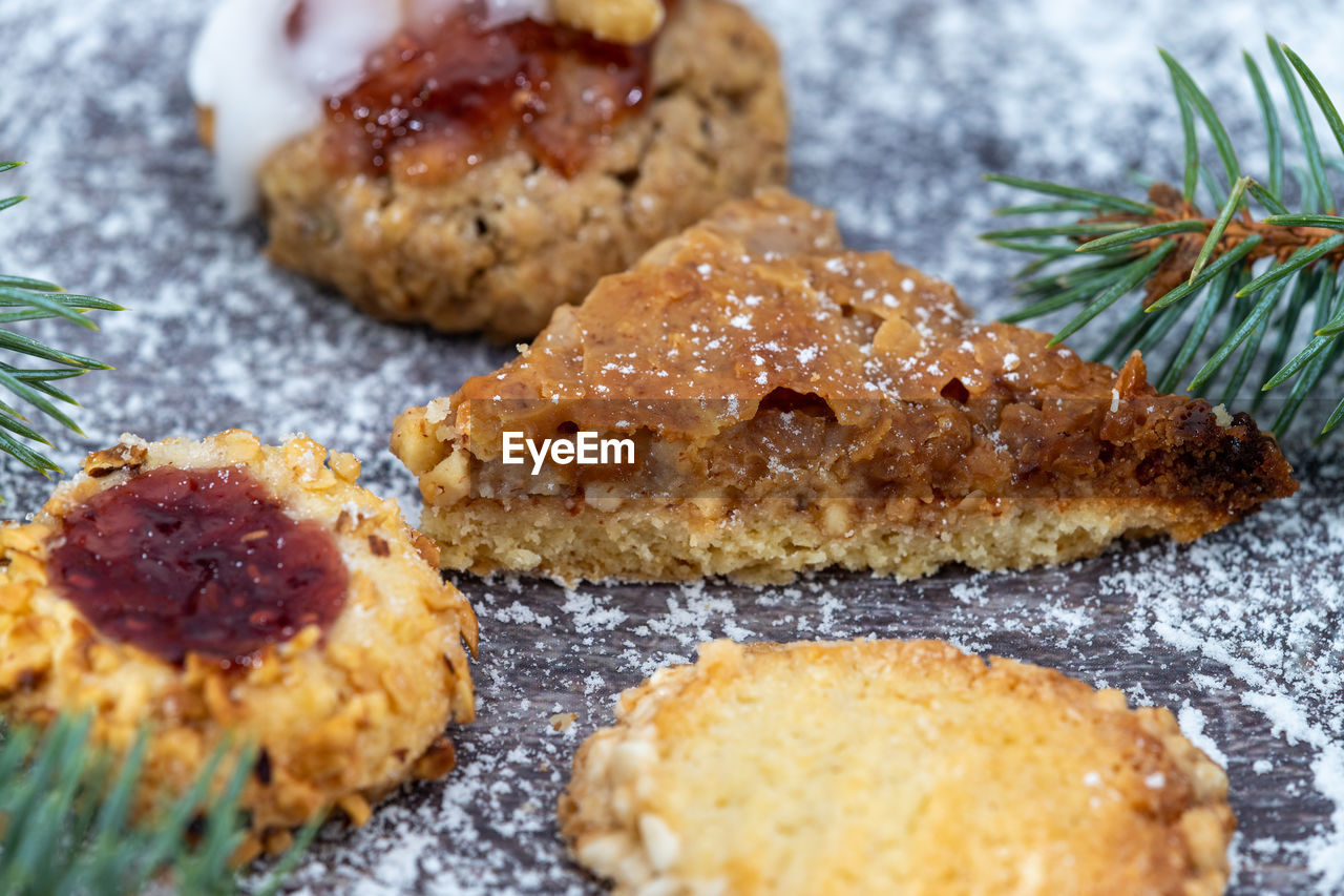 Close-up of various christmas cookies surrounded with powdered sugar and fir branches