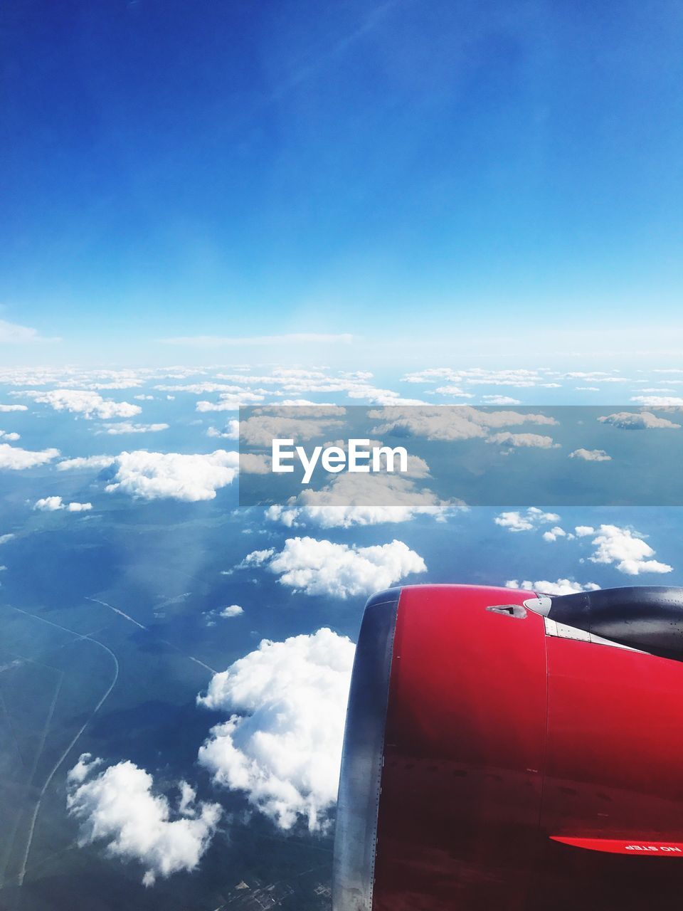 AERIAL VIEW OF AIRPLANE WING OVER CLOUDS