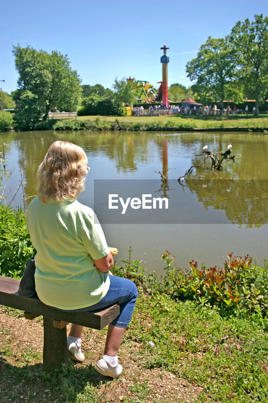 Woman sitting at lakeshore