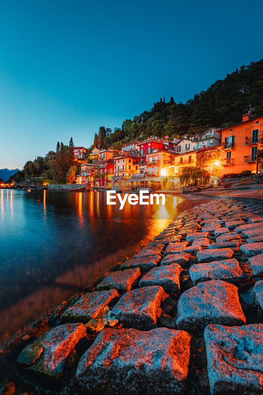 Village of varenna on lake como at sunset with illuminated houses