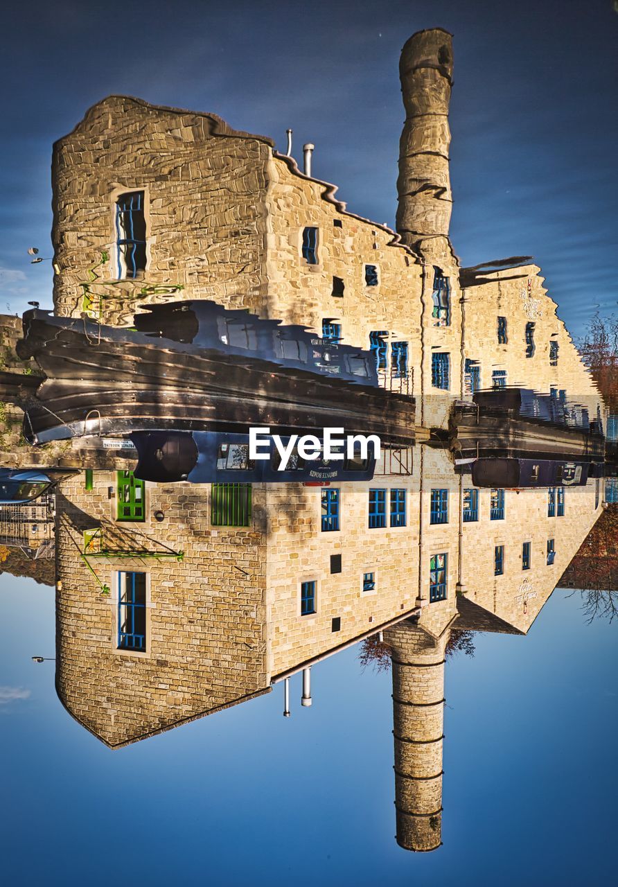 REFLECTION OF OLD BUILDING AGAINST SKY