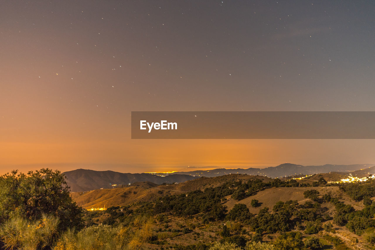 SCENIC VIEW OF LANDSCAPE AGAINST ORANGE SKY