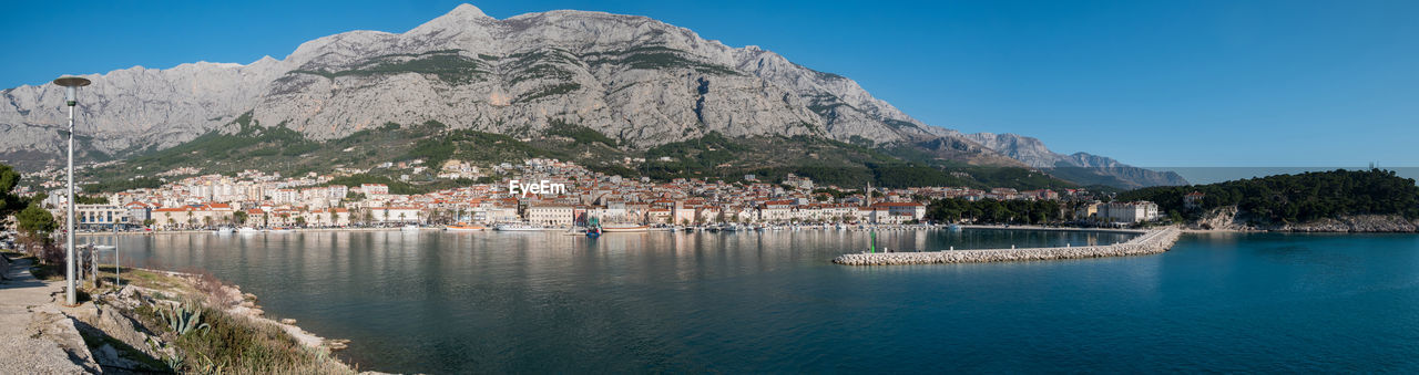 Scenic view of sea by buildings against sky