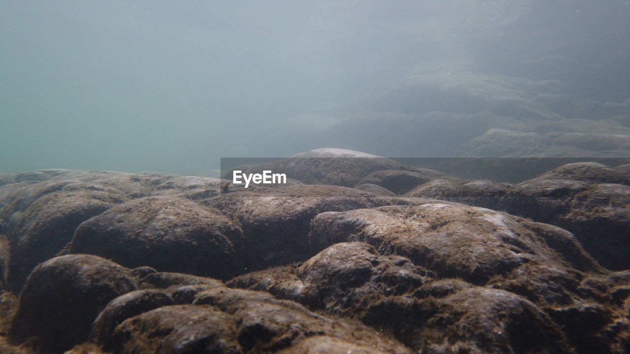 Rock formation in sea against sky