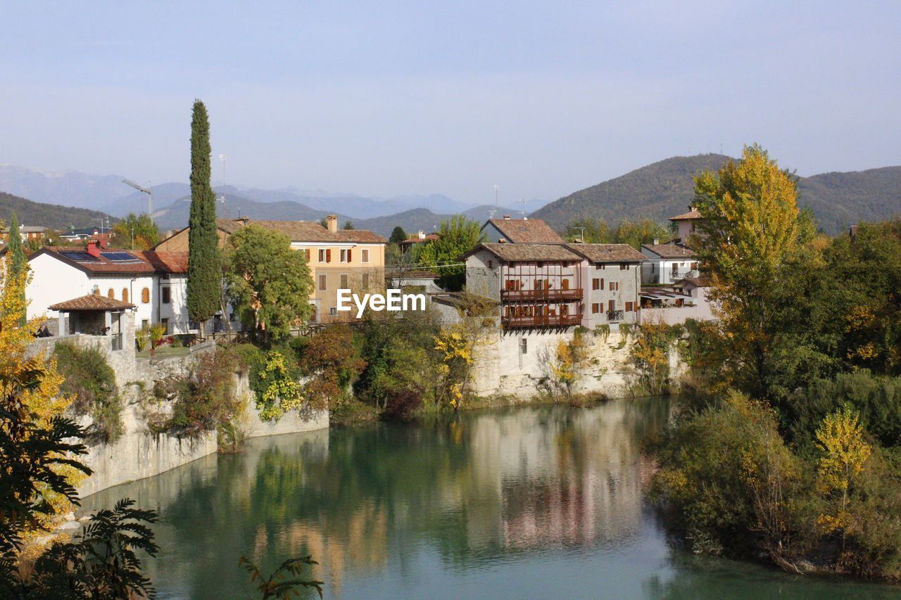 RIVER AMIDST BUILDINGS AGAINST SKY