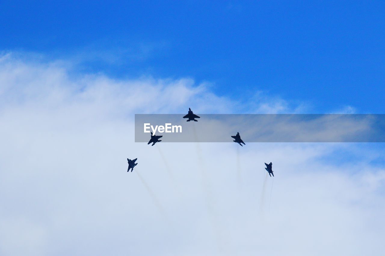 Low angle view of airplanes flying in sky