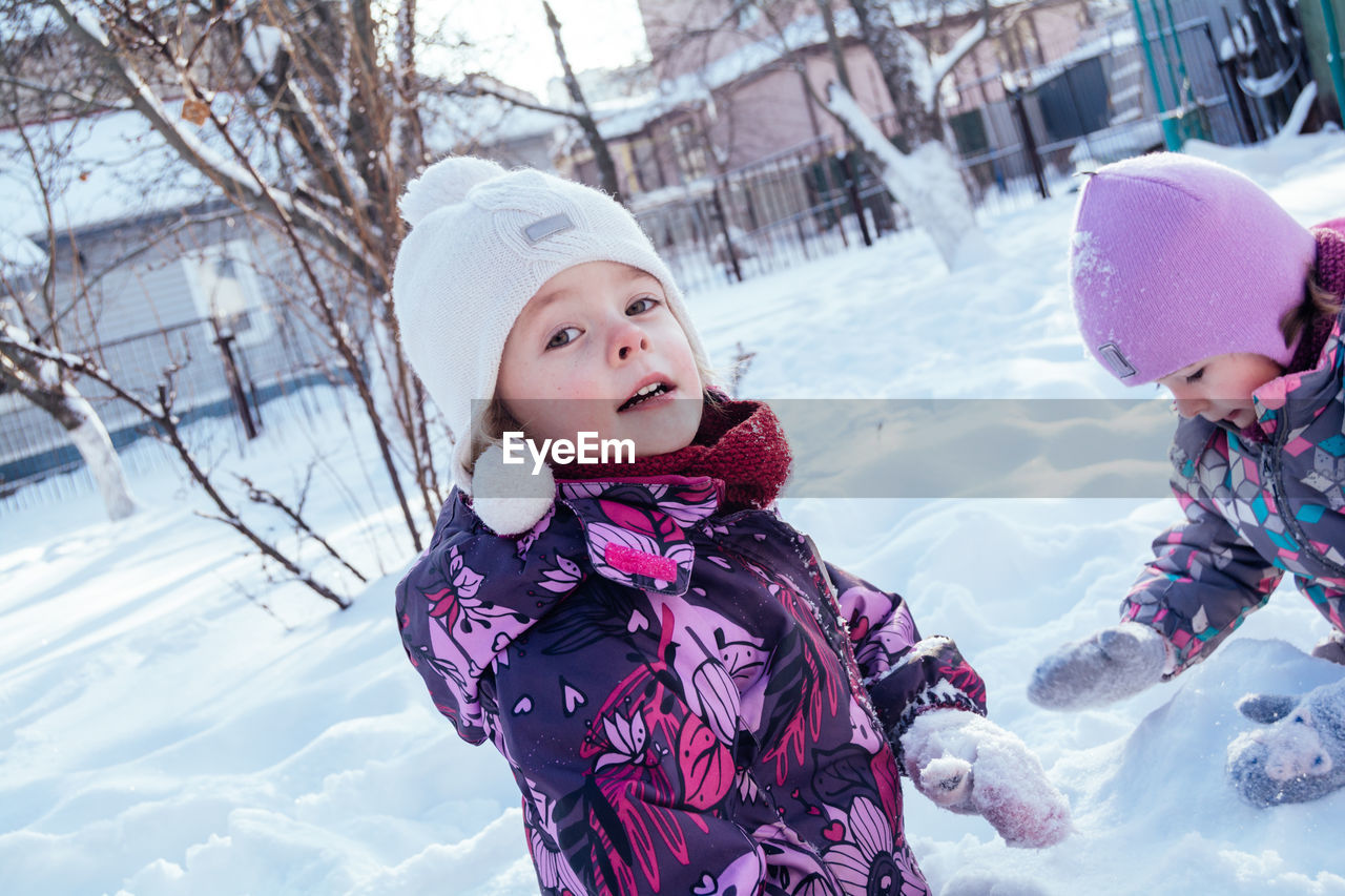 Children playing with snow outdoors. winter holidays in the countryside