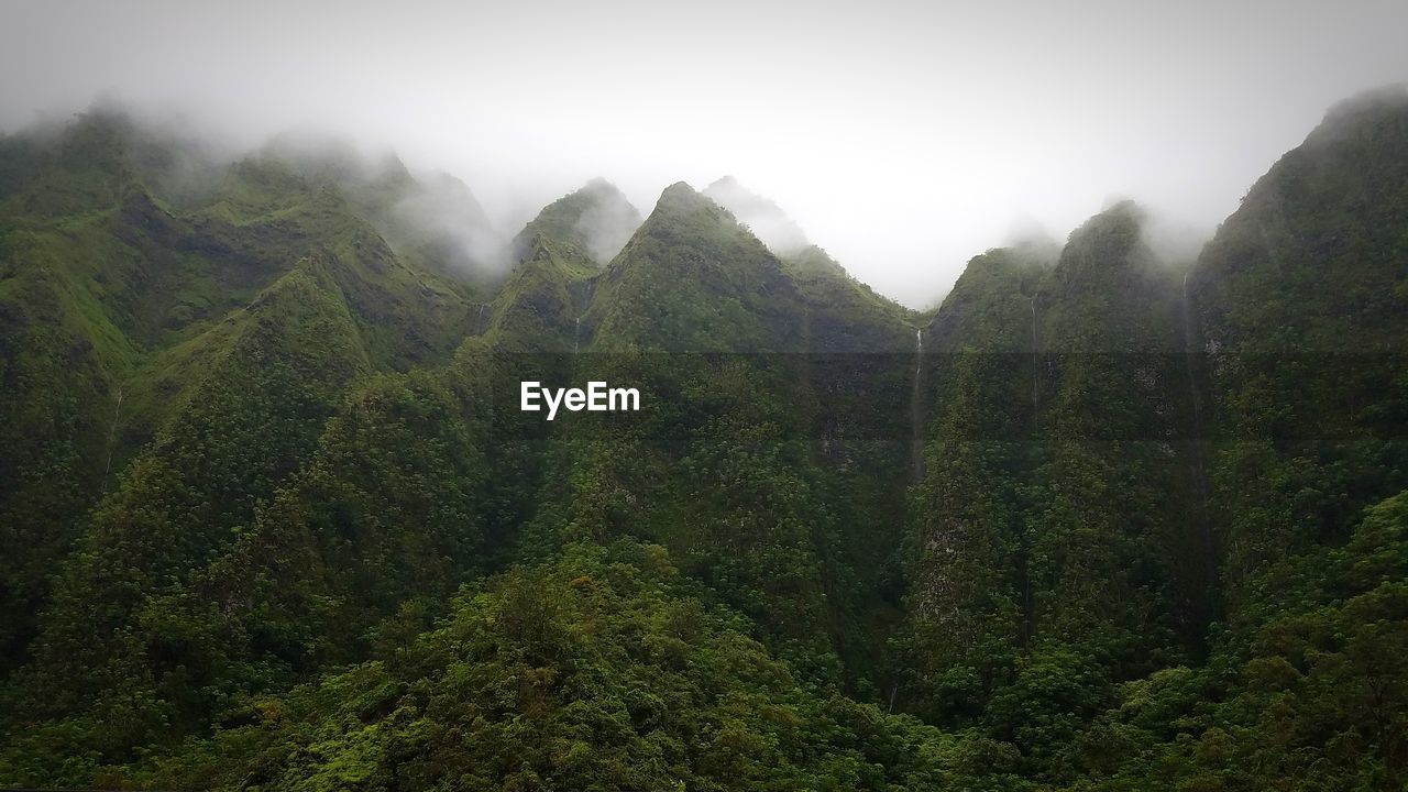 Scenic view of mountains during foggy weather against sky