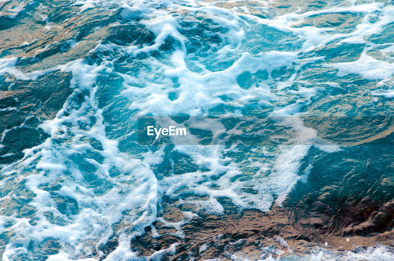 Foamy water waves at the ocean, view from above. top view sea texture. photo with motion blur.