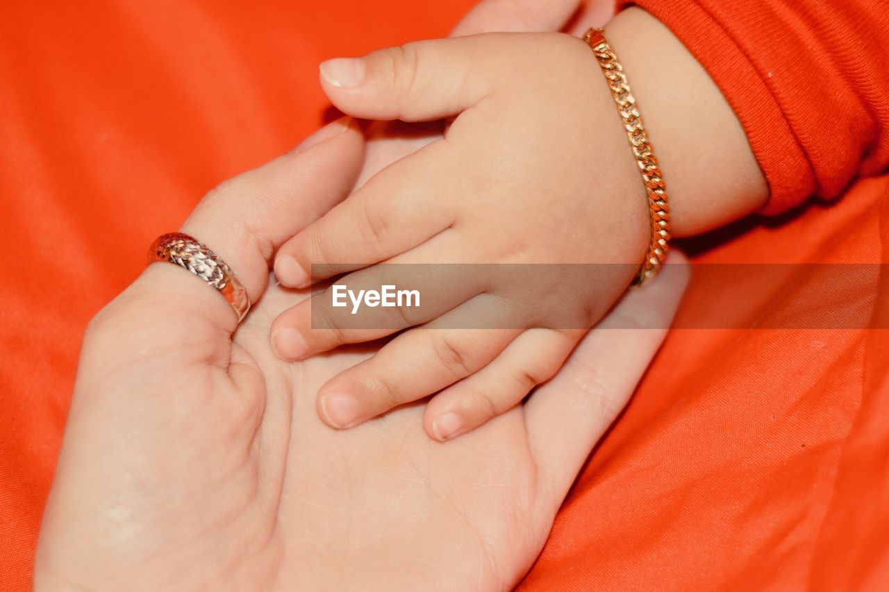 Cropped hand of mother holding baby girl