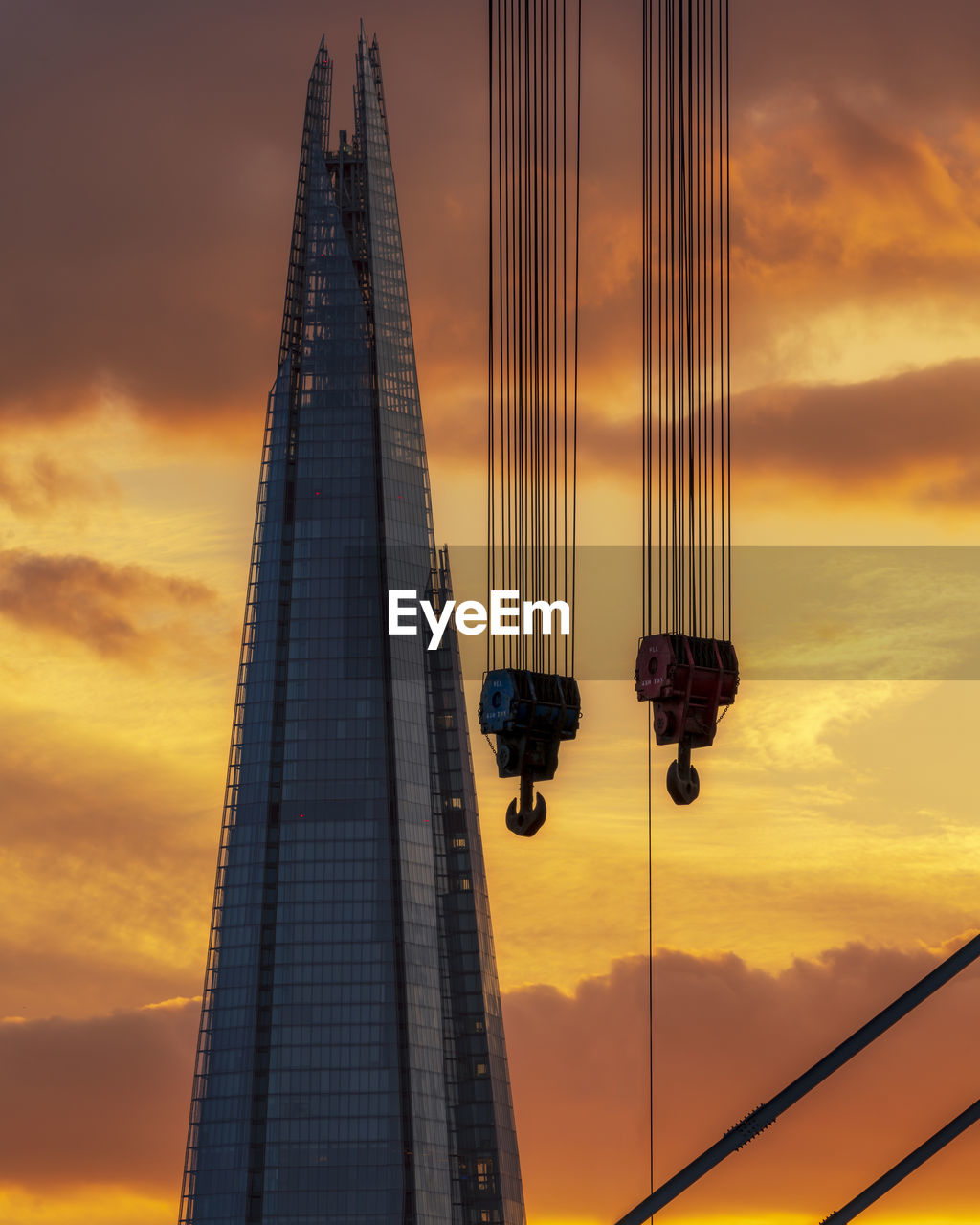 LOW ANGLE VIEW OF SKYSCRAPERS AGAINST CLOUDY SKY