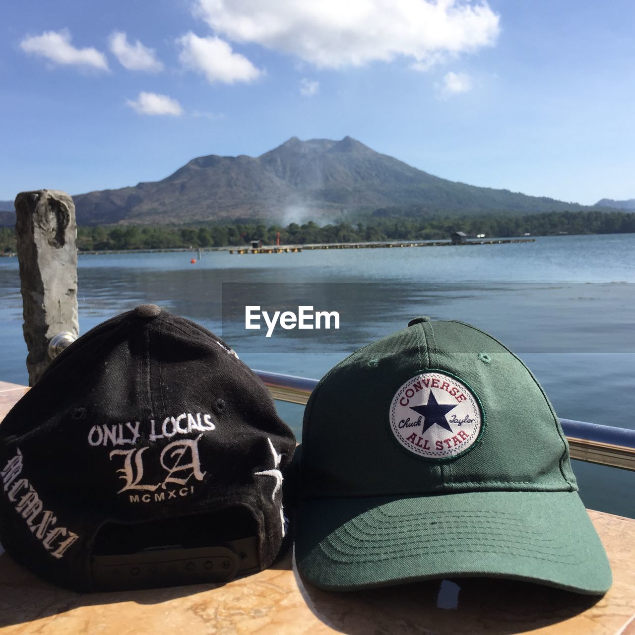 CLOSE-UP OF HAT ON LAKE AGAINST MOUNTAINS