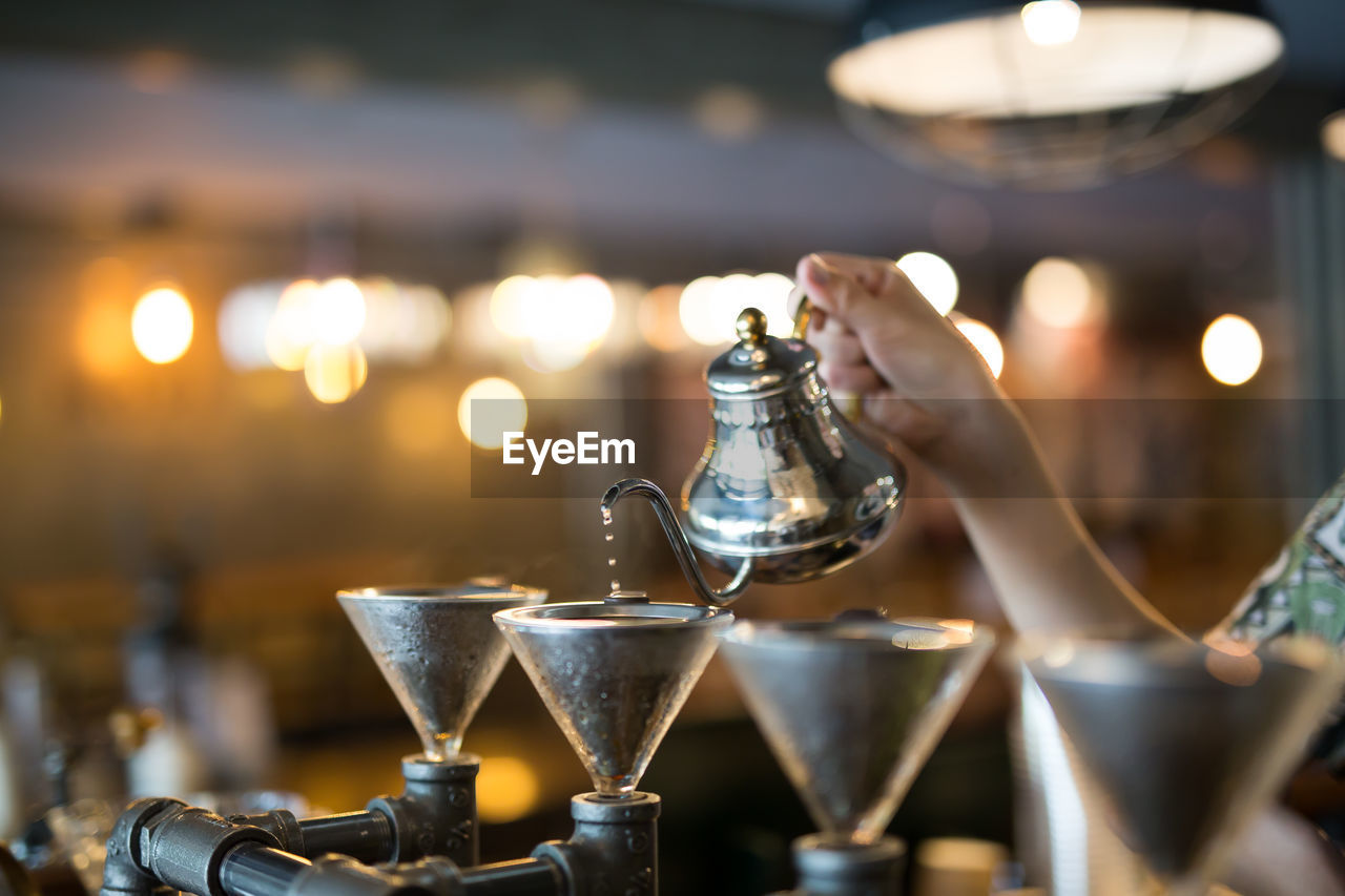 Close-up of woman pouring drink in glass