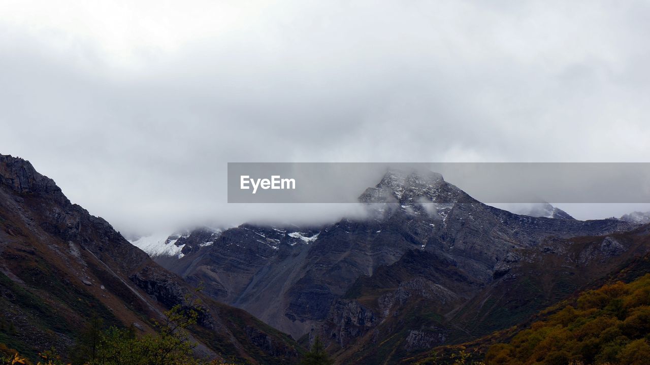 Scenic view of mountains against cloudy sky