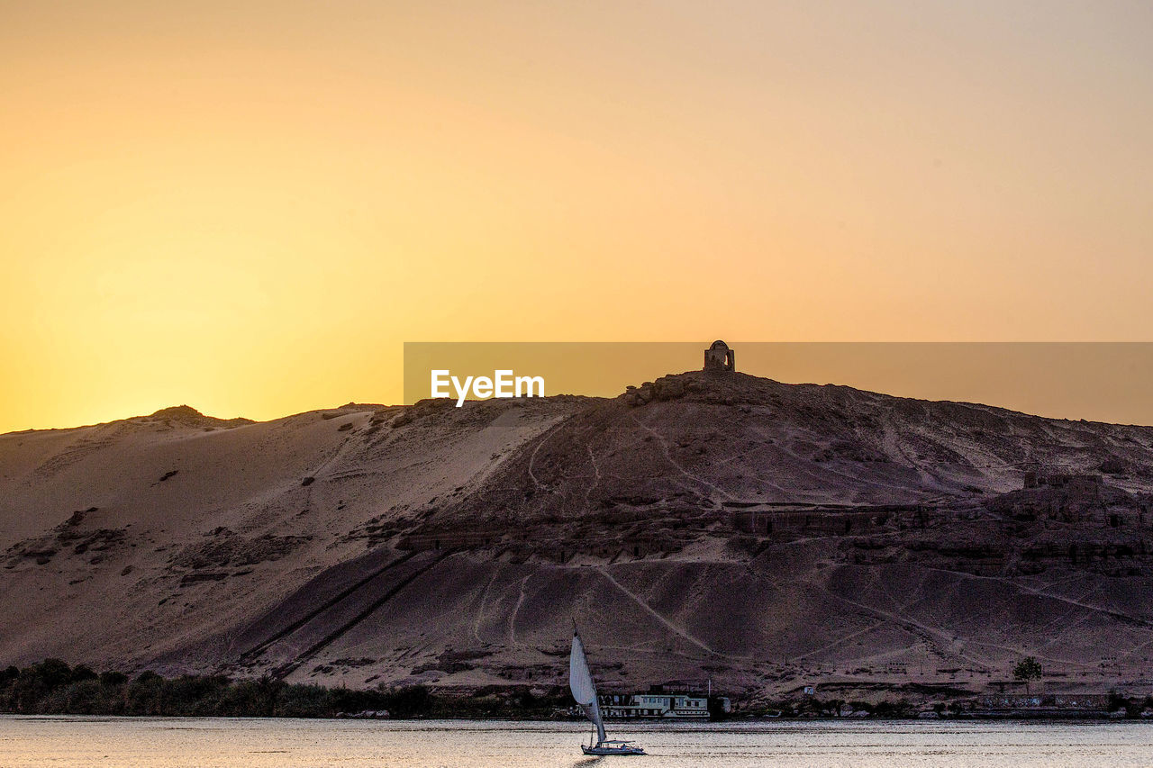 SCENIC VIEW OF MOUNTAINS AGAINST CLEAR SKY AT SUNSET