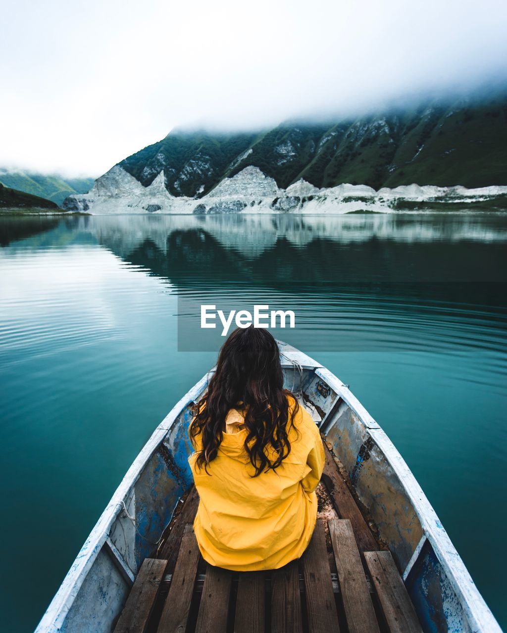 REAR VIEW OF WOMAN LOOKING AT LAKE BY MOUNTAINS