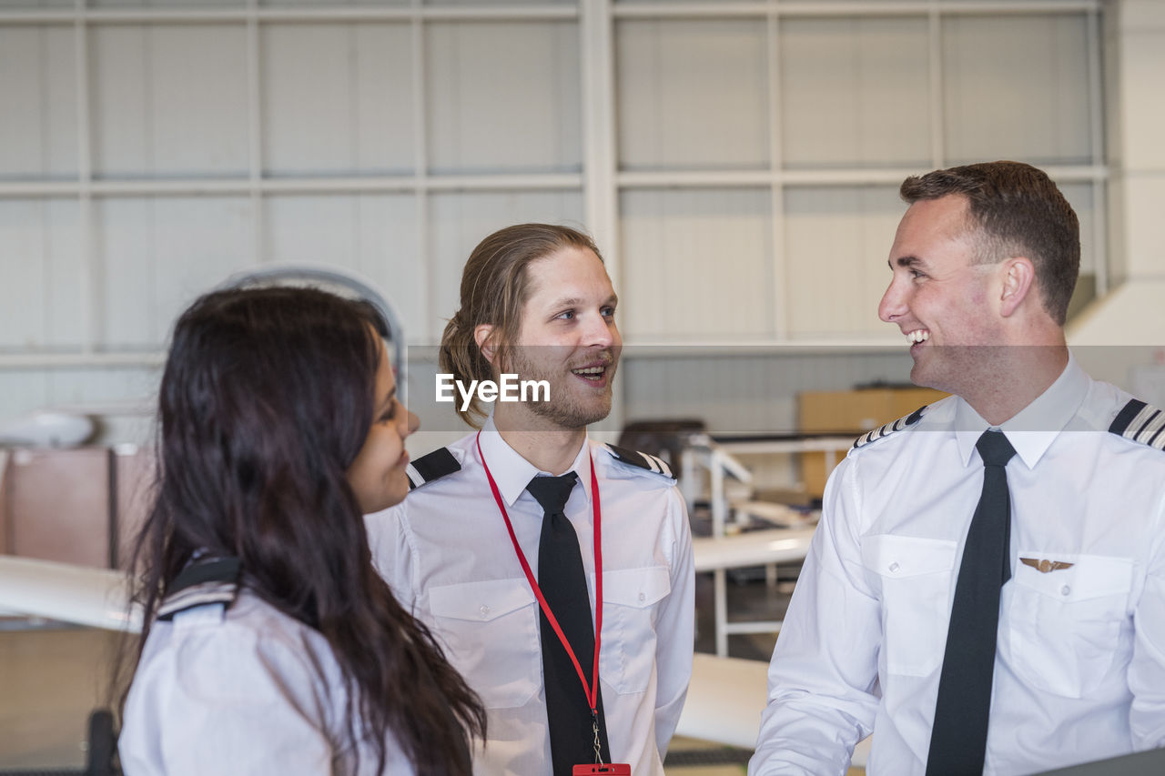 Engineers smiling while standing in airplane hangar