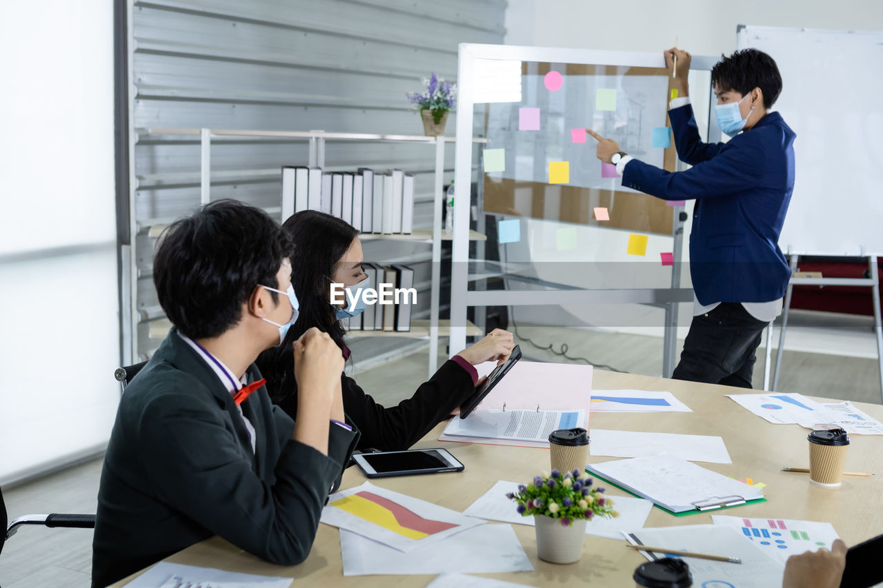 PEOPLE WORKING ON TABLE AT OFFICE