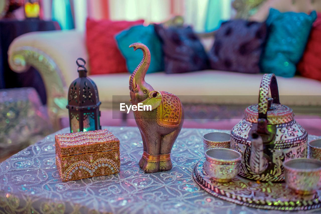 Close-up of figurines and antique crockery on coffee table during wedding