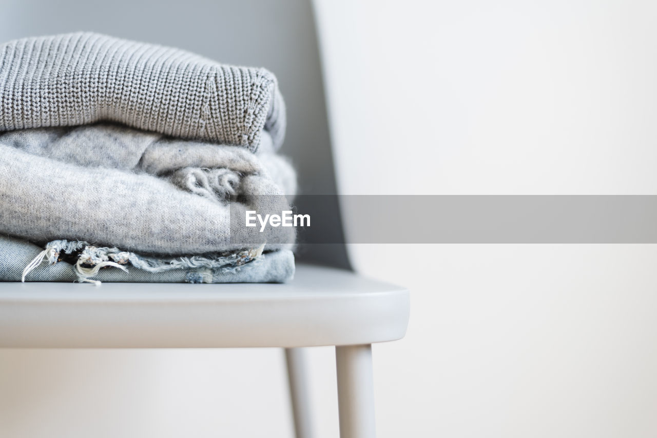 Stack of sweaters on chair