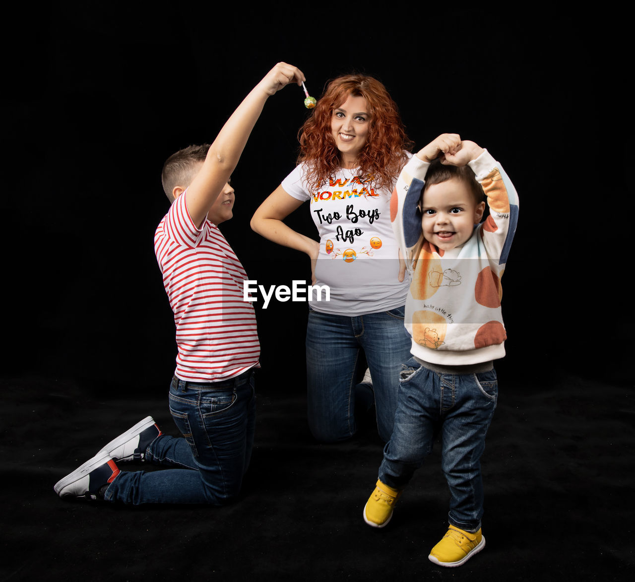 FULL LENGTH PORTRAIT OF A GIRL STANDING AGAINST BLACK BACKGROUND