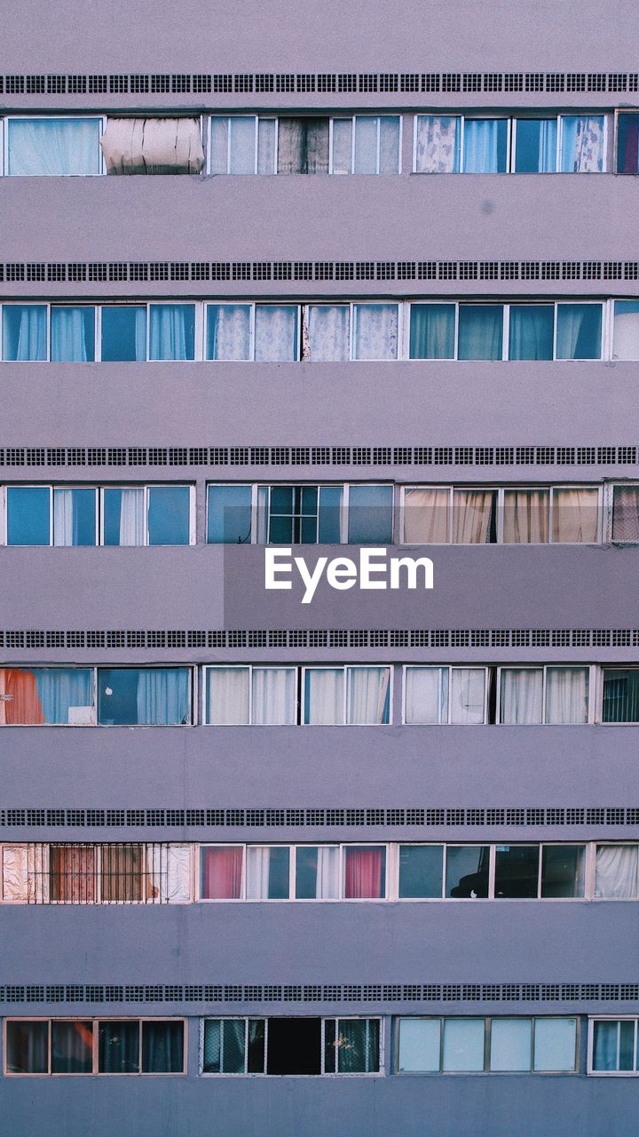 Full frame shot of apartment building purple, windows 