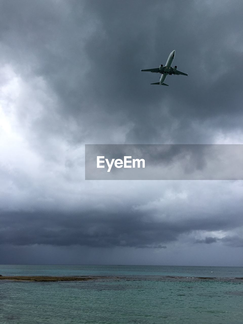 Low angle view of airplane flying over sea
