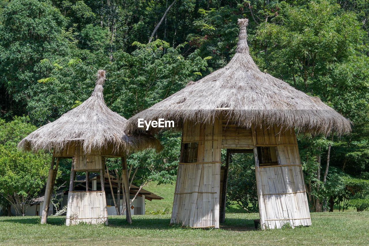 TRADITIONAL WINDMILL ON FIELD BY TREES AND BUILDING