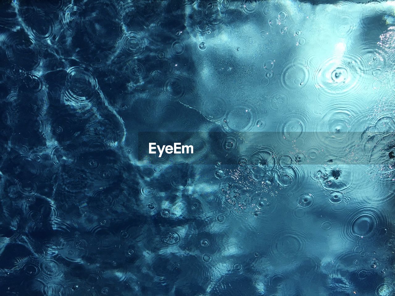 High angle view of raindrops on swimming pool